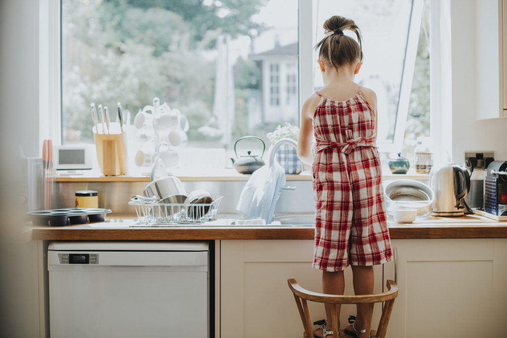 little girl doing dishes